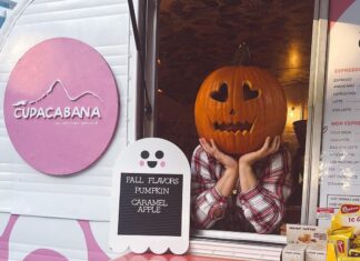 a person holding a pumpkin in front of a window