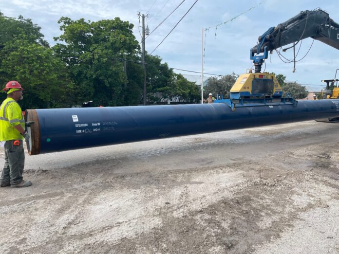 a man standing next to a large pipe