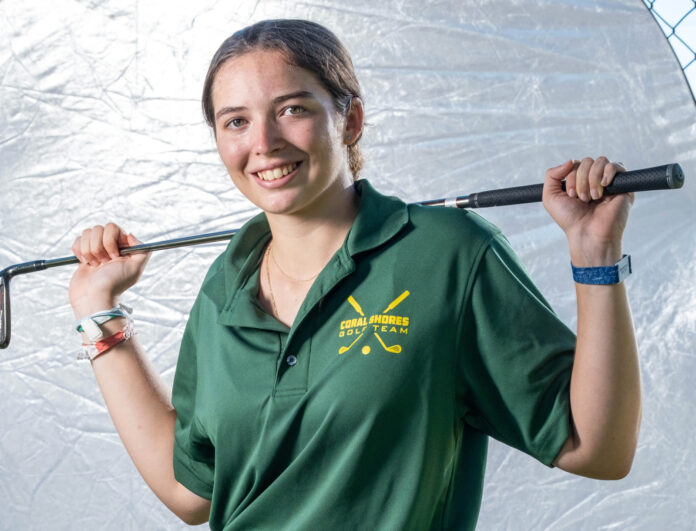 a woman in a green shirt holding a baseball bat