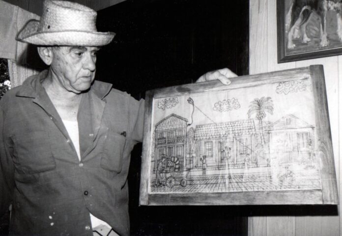 a man in a hat is holding a picture