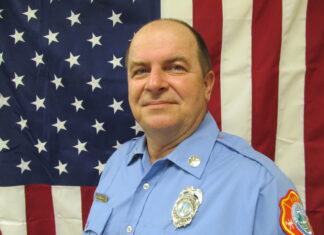 a police officer standing in front of an american flag