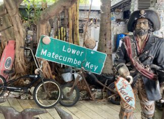 a statue of a pirate holding a sign next to a motorcycle