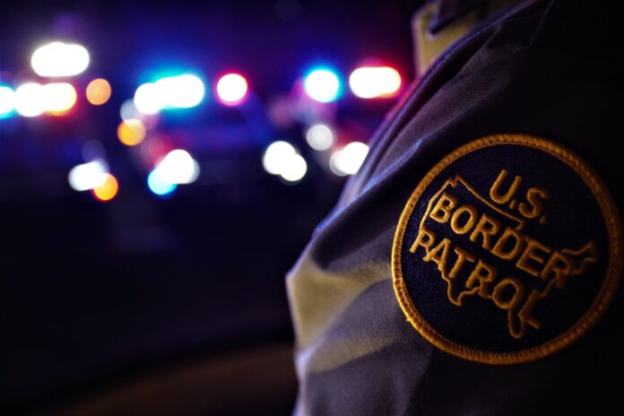 a us border patrol officer standing in front of a lot of lights