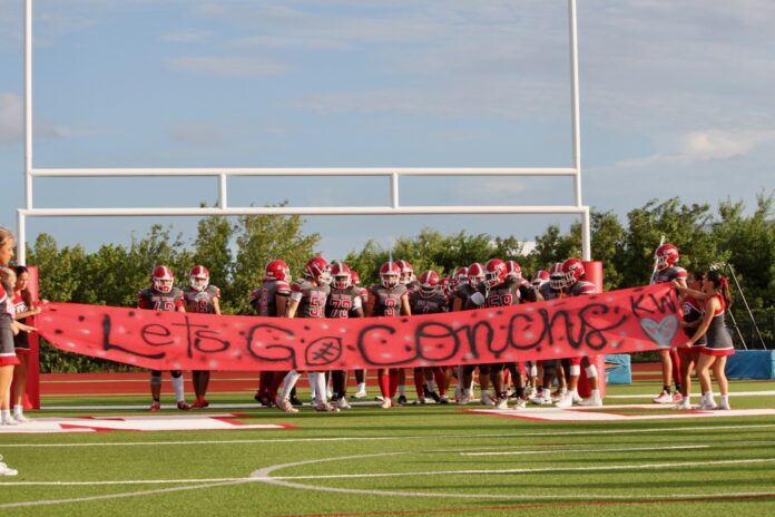 a group of people standing on top of a football field