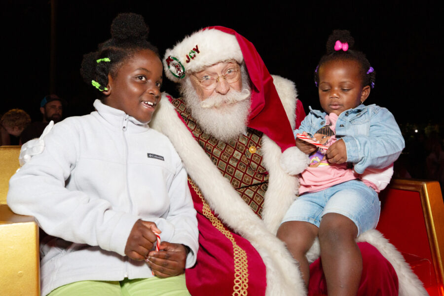 Zamaria Smith, 10, left, shares a Christmas wish with Santa Claus, while her sister Laneice, 2, checks out a candy cane during the lighting of the City of Key West's Christmas tree event at Bayview Park on Nov. 27, 2023. CAROL TEDESCO/
KeyWestHolidayFest.com