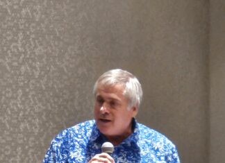 NEWMAN GETS PROBATION, COMMUNITY SERVICE IN CASE OVER TOURISM WORK PAYMENTS TO UNREGISTERED COMPANY a man standing in front of a microphone