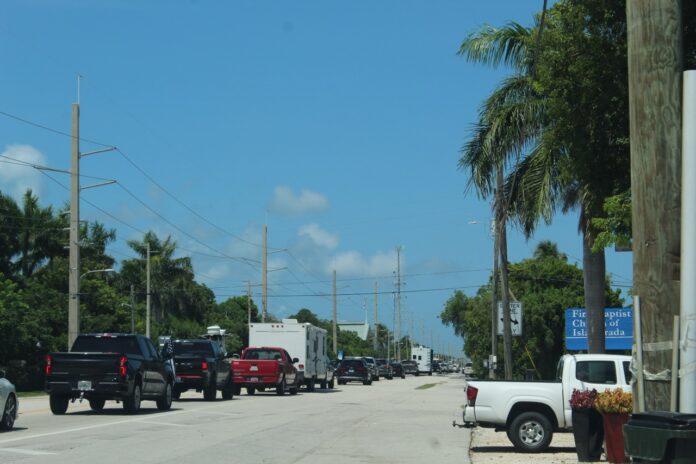 a street filled with lots of traffic next to palm trees