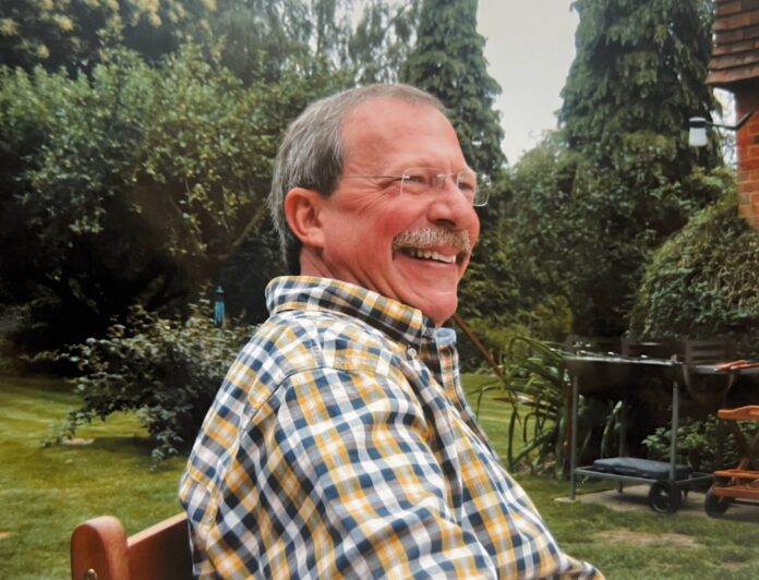 a man sitting on a bench in a yard