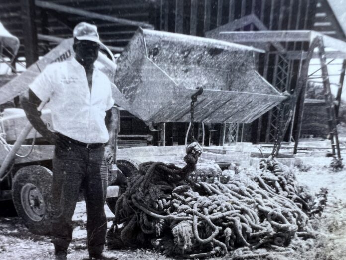 a man standing next to a pile of chains