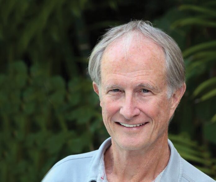 a man in a blue shirt smiles at the camera