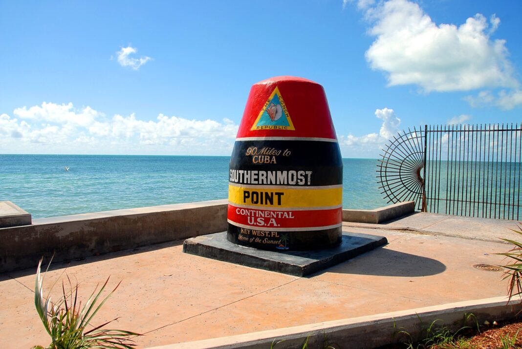 a red, yellow, and black sign sitting on top of a cement slab
