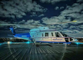 a blue and white helicopter sitting on top of a tarmac
