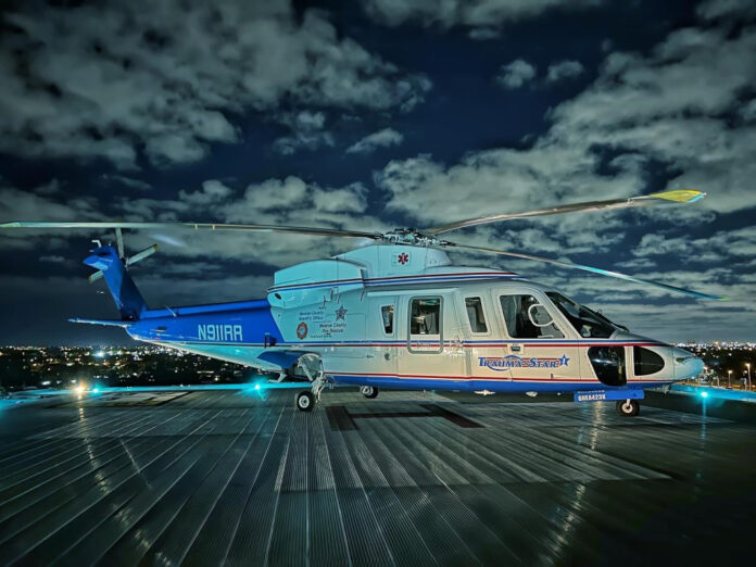 a blue and white helicopter sitting on top of a tarmac