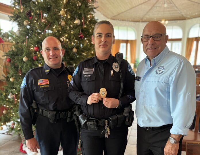 three police officers posing for a picture in front of a christmas tree