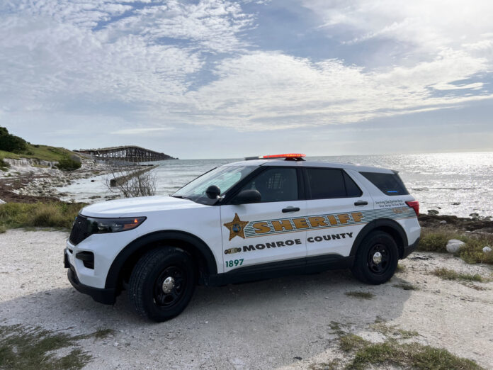 a police car parked on a beach near the ocean