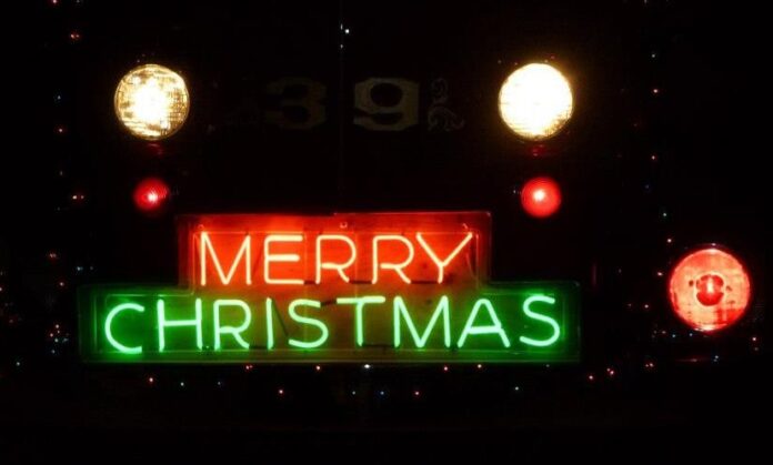 a merry christmas sign lit up at night