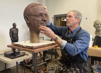 a man is working on a sculpture of a man's head