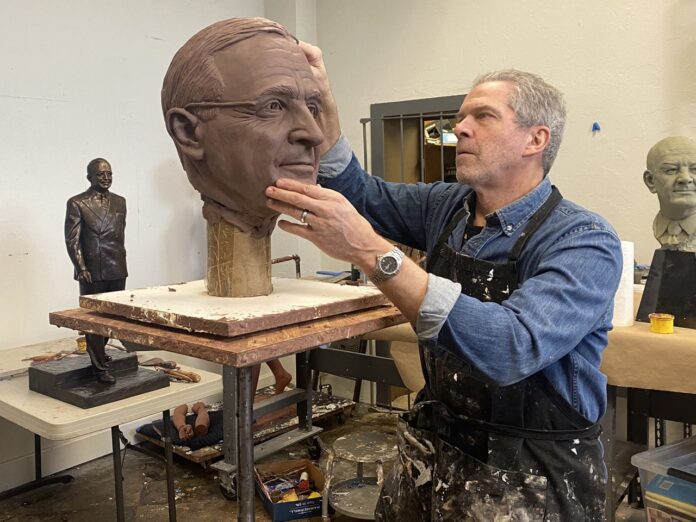 a man is working on a sculpture of a man's head