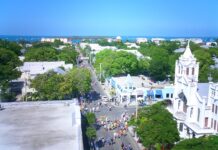 an aerial view of a city street with a church in the background