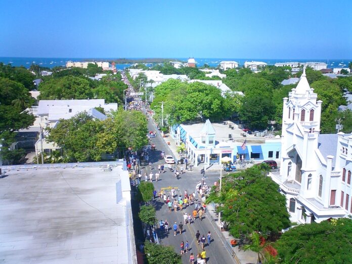 an aerial view of a city street with a church in the background