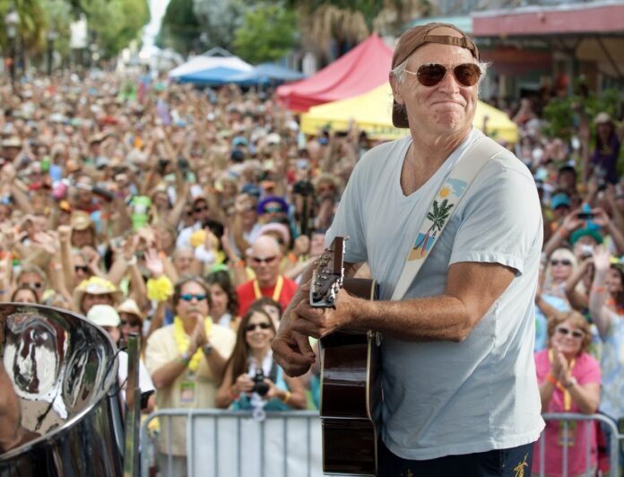 a man holding a guitar in front of a crowd of people