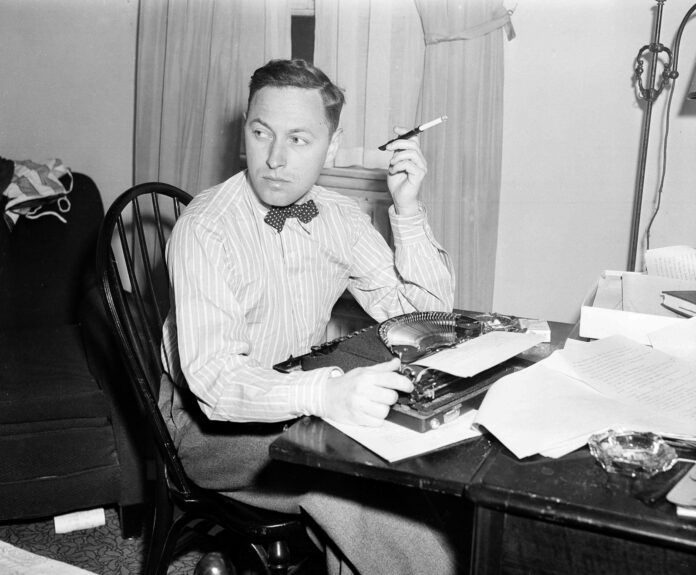 a man sitting at a desk smoking a cigarette