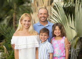 a family posing for a picture in front of a palm tree