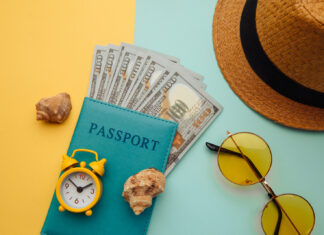 a passport, sunglasses, money, and a hat on a blue and yellow background