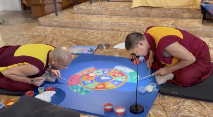 a couple of men sitting on top of a blue table