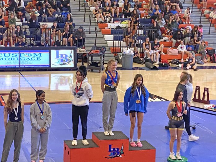 a group of young women standing on top of a basketball court