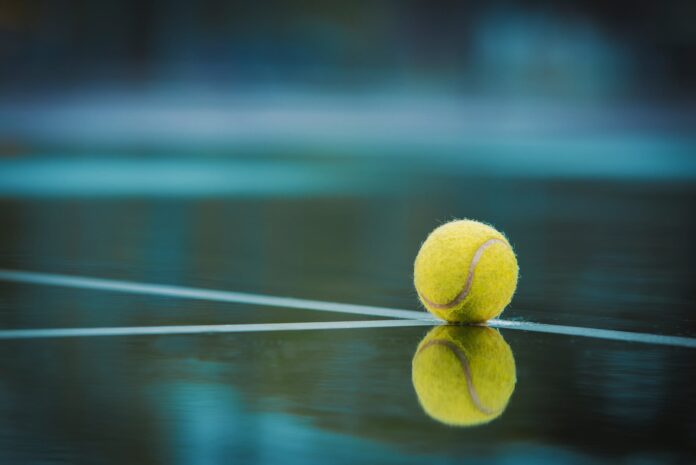 a tennis ball sitting on top of a tennis court