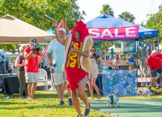 a man in a hot dog costume running on a race track