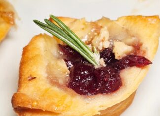 a white plate topped with pastries covered in cranberry sauce