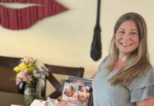 a woman standing in front of a table with a magazine on it