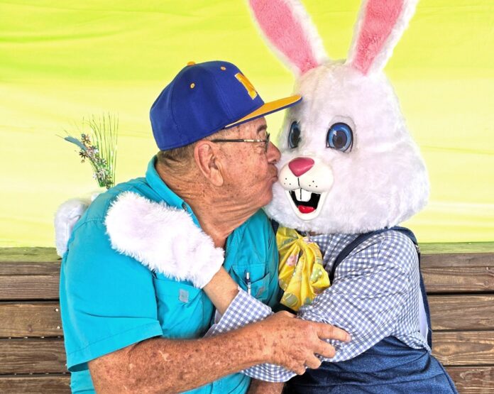a man in a blue shirt hugging a white bunny