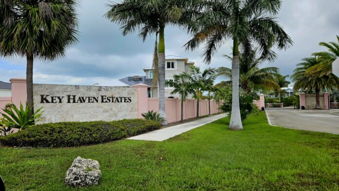 a sign for key haven estate with palm trees