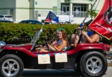 a group of people riding in a car with flags