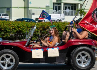 a group of people riding in a car with flags