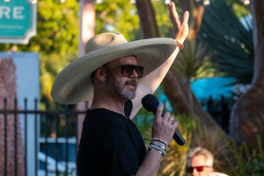 a man wearing a hat and holding a microphone