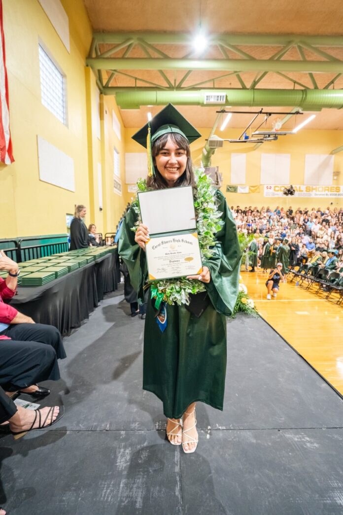 a woman in a graduation gown holding a diploma