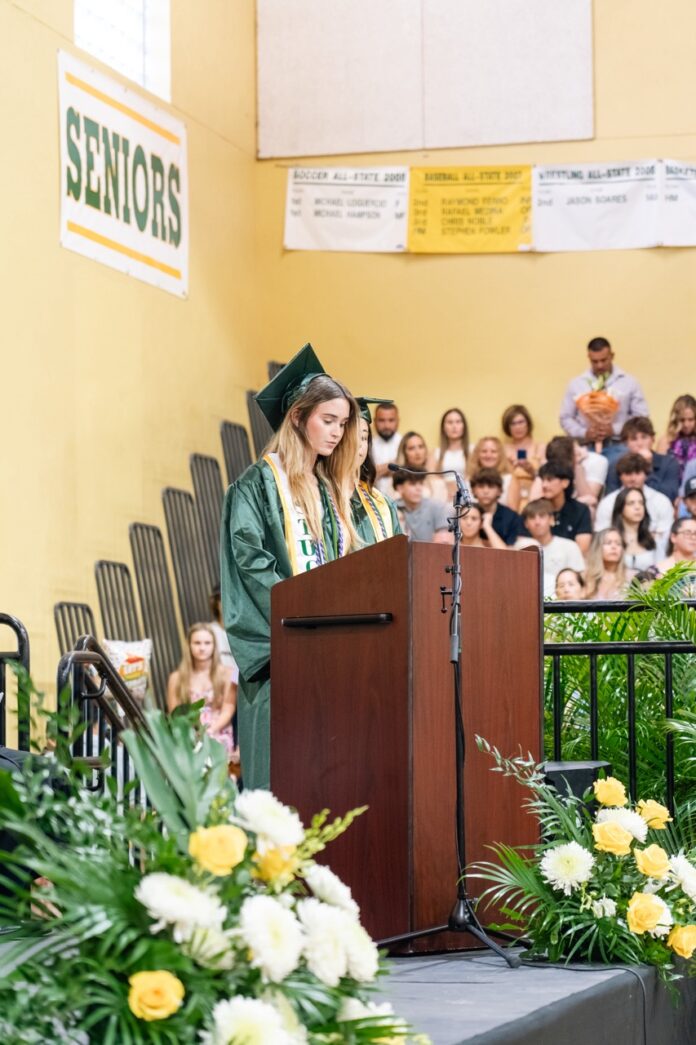 a woman standing at a podium in front of a crowd