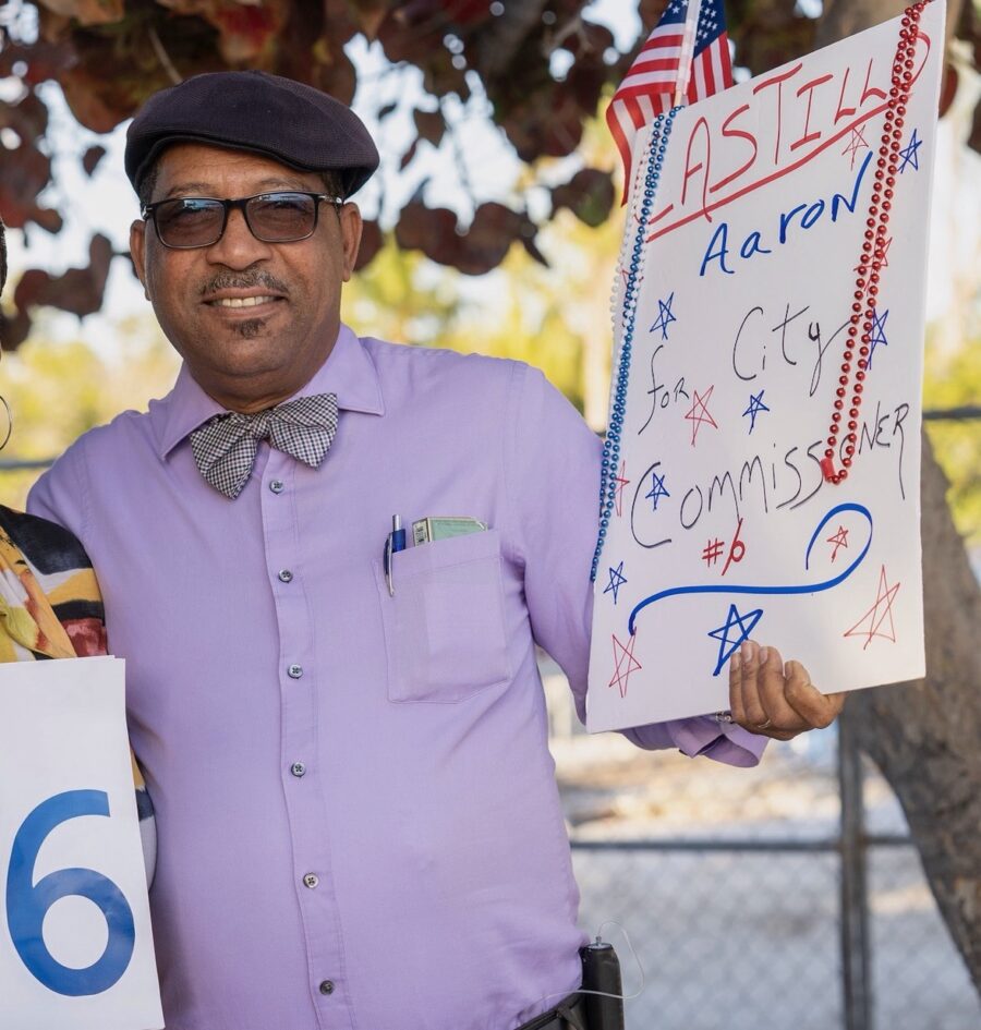 a man and a woman holding signs under a tree