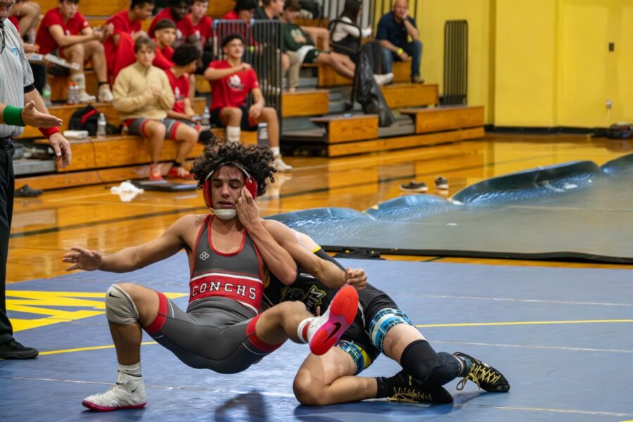 a wrestling match with a referee looking on