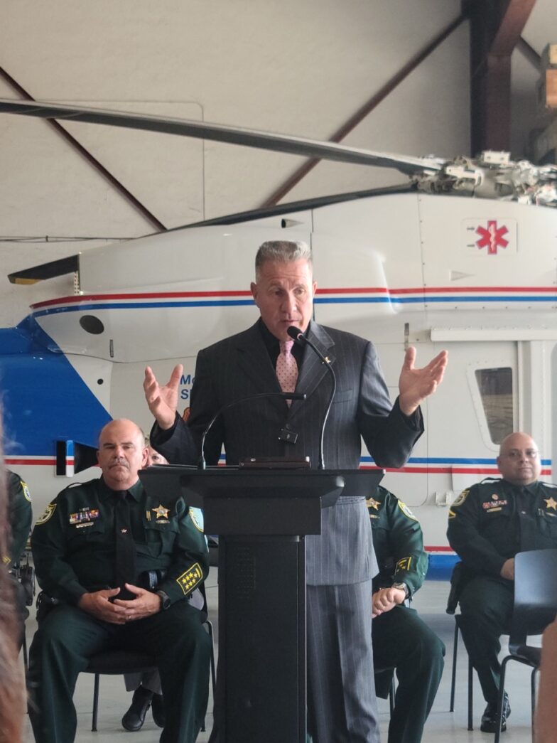a man standing at a podium in front of a group of people