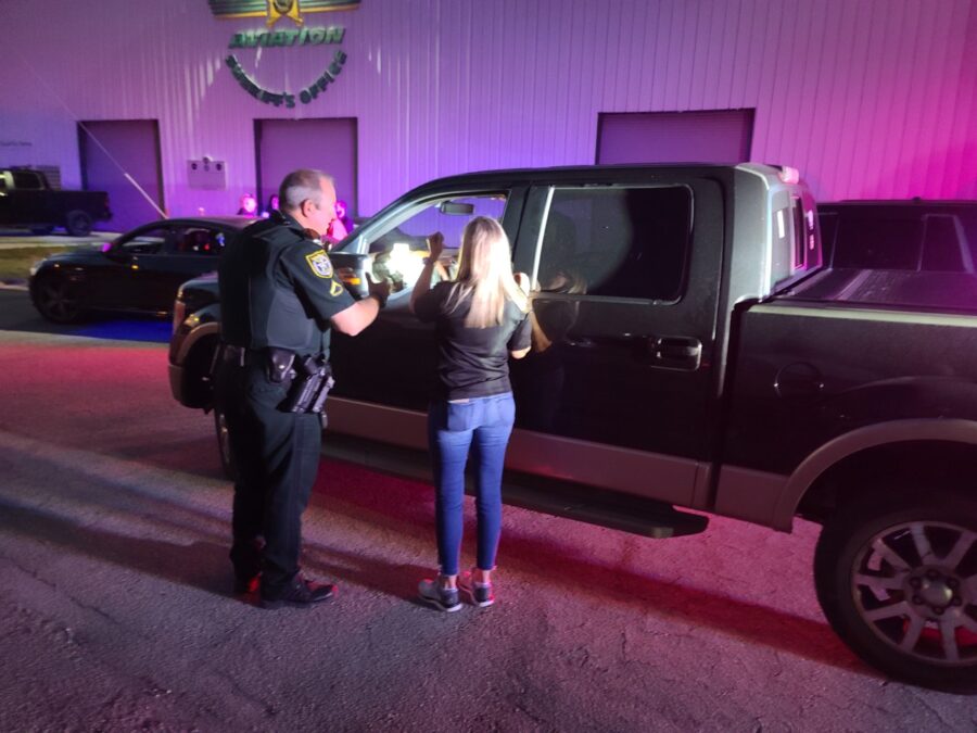 a police officer talking to a woman in front of a truck
