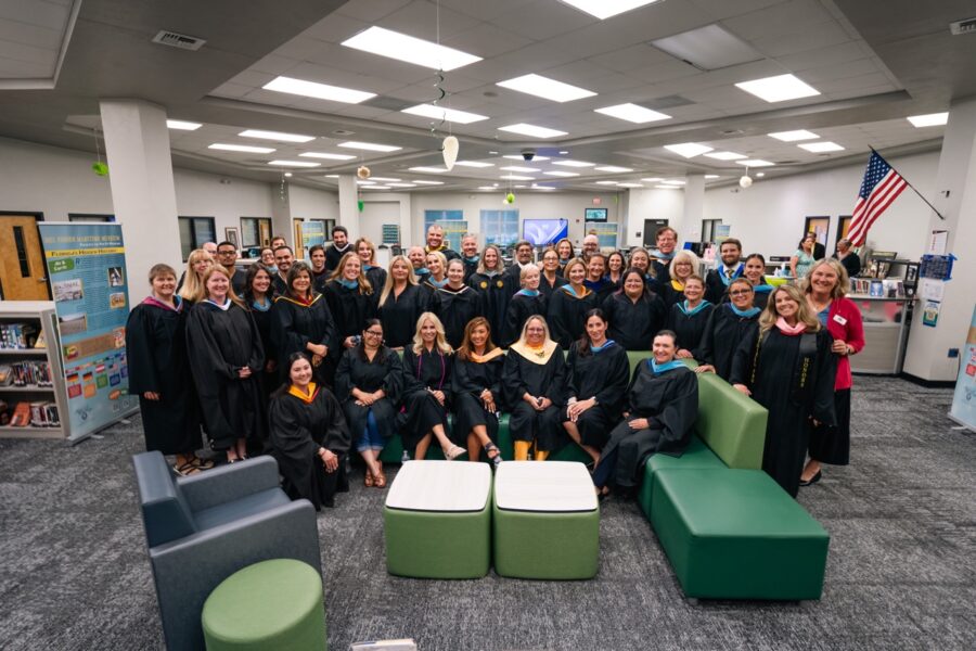 a group of people in graduation gowns posing for a picture