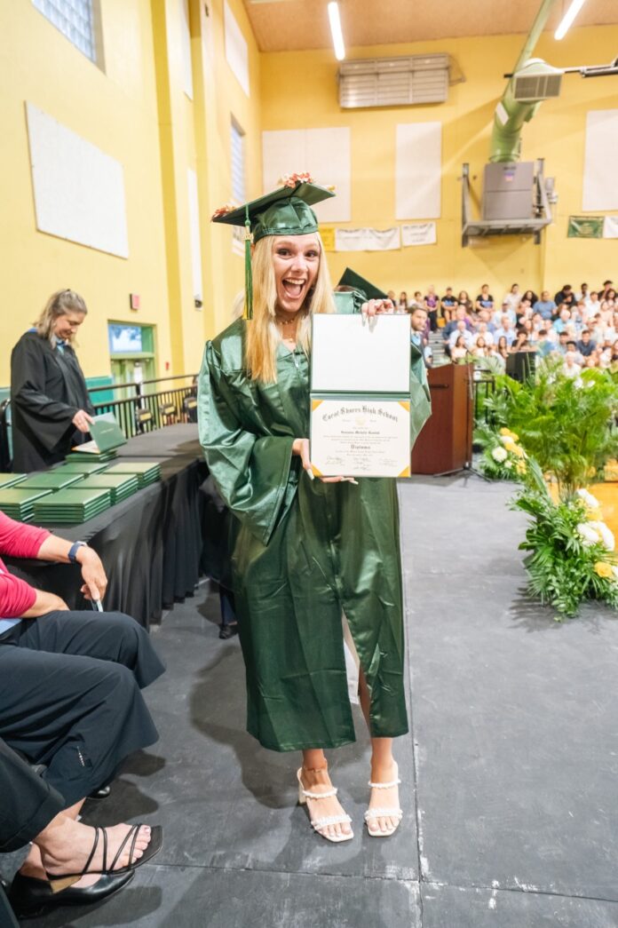 a woman in a graduation gown holding a diploma