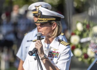 a woman in a military uniform speaking into a microphone