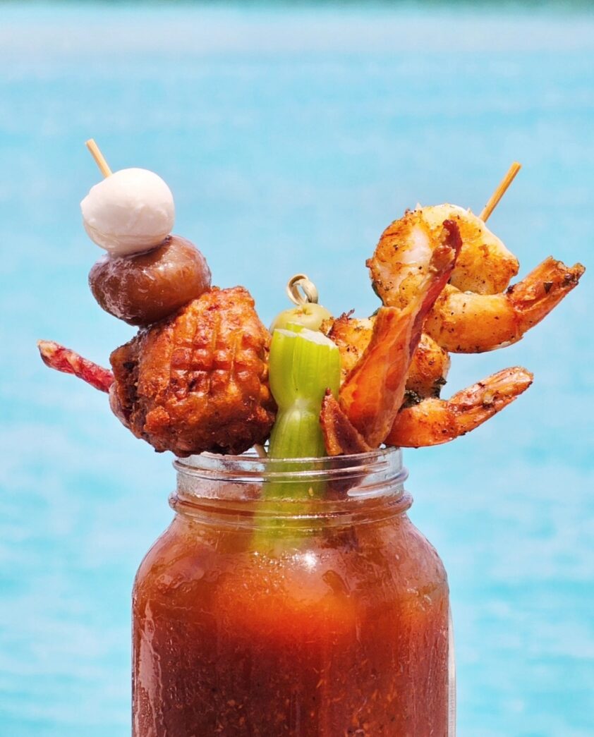 a mason jar filled with food next to a body of water