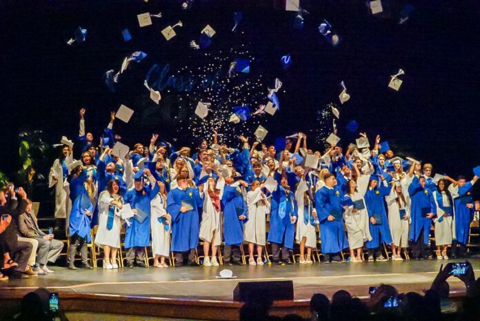 a group of graduates throwing their caps in the air